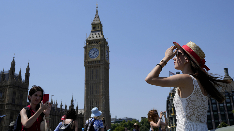 Tourists pose for photographs on Westminster Bridge in London, Tuesday, July 19, 2022. Millions of people in Britain woke from the country's warmest-ever night on Tuesday and braced for a day when temperatures could break records, as a heat wave scorching Europe walloped a country not built for such extremes. (AP Photo/Frank Augstein)