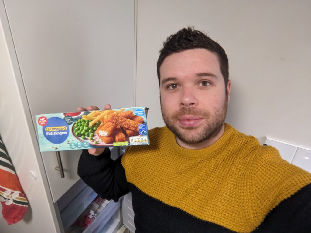 Male holding packet of fish fingers